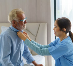 lady helping elderly man to dress up