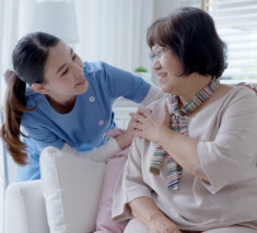 lady tapping the shoulder of elderly woman