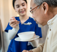 Lady feeding elderly man