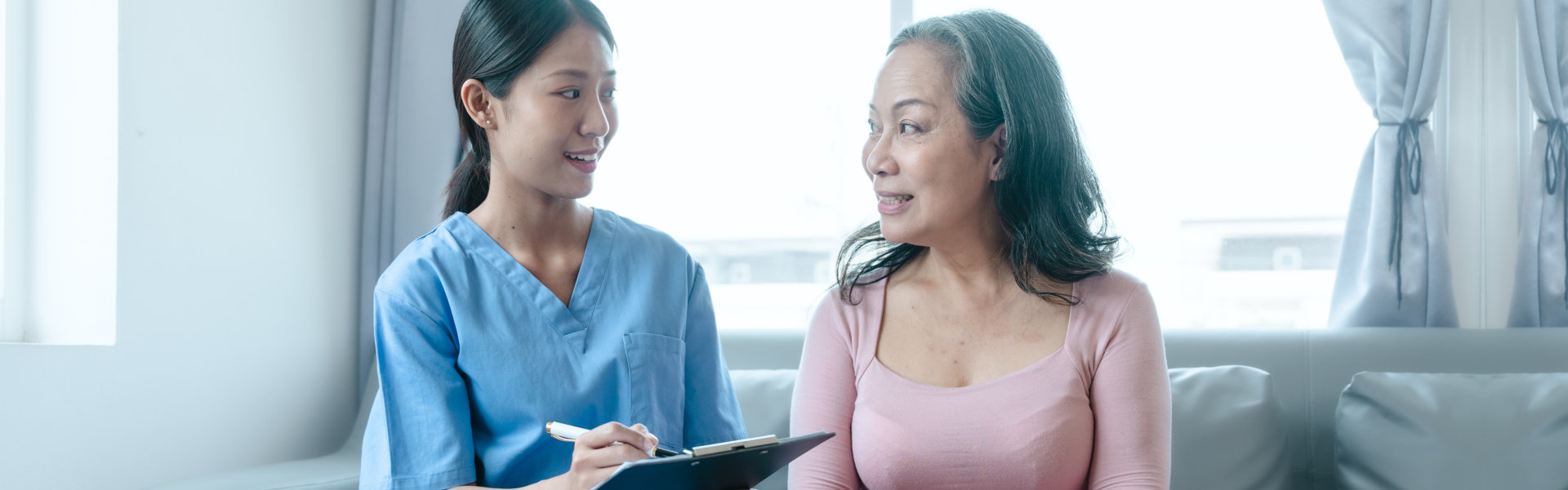 Lady holding a clip board looking at elderly